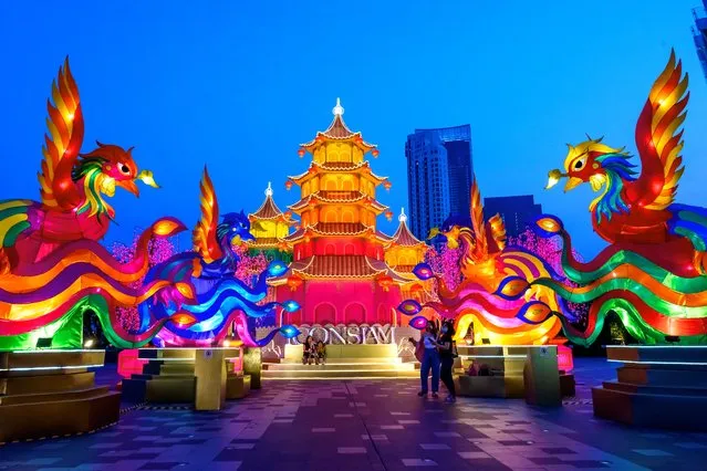 People visit a festive installation of illuminated pagodas and mythical animals erected outside a shopping mall to celebrate the upcoming Lunar New Year in Bangkok, Thailand on January 29, 2021. (Photo by Mladen Antonov/AFP Photo)