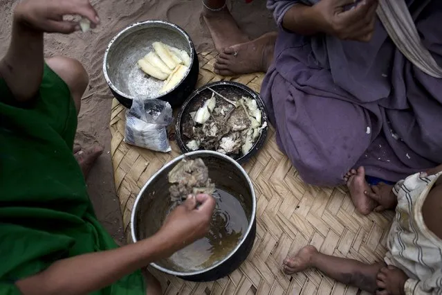 In this November 19, 2015 photo, an Ashaninka family eats grilled fish and boiled yuca for breakfast, the indigenous community's staple diet, in their home in Pichiquia, in Peru's Junin region. In the village there also are tropical fruits such as bananas and mangos, chicken or fish caught from the river, which also provides drinking water and a place to bathe. (Photo by Rodrigo Abd/AP Photo)