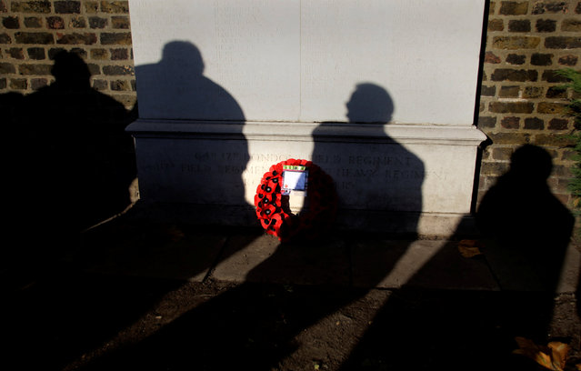 Shadows are cast as people look at a wreath placed by Fulham War Memorial during a Remembrance Sunday parade through Fulham in West London, Britain November 13, 2011. (Photo by Kevin Coombs/Reuters)