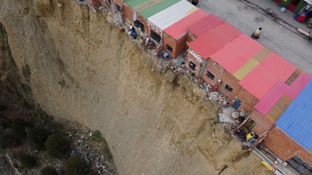A drone view shows a row of houses, locally known as “suicide homes” dwellings built on the edge of an earth cliff and often serving as workplaces for Aymara shamans, in El Alto, Bolivia on December 11, 2024. (Photo by Claudia Morales/Reuters)