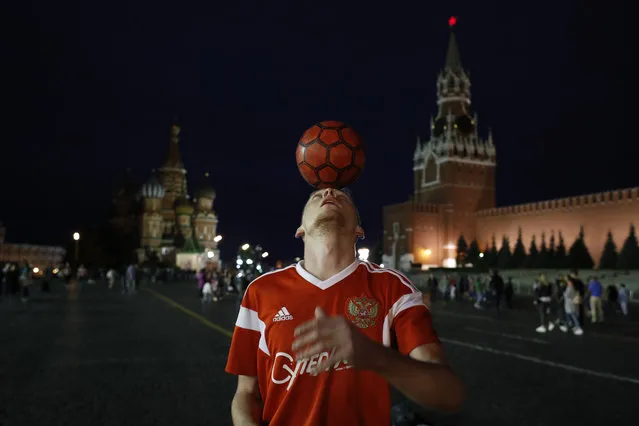 A Russian soccer fan shows off his ball skills as he plays with tourists and soccer fans in Red Square during the 2018 soccer World Cup in Moscow, Russia, Tuesday, July 3, 2018. (Photo by Hassan Ammar/AP Photo)