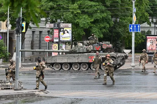 Fighters of Wagner private mercenary group cross a street as they get deployed near the headquarters of the Southern Military District in the city of Rostov-on-Don, Russia on June 24, 2023. (Photo by Reuters/Stringer)