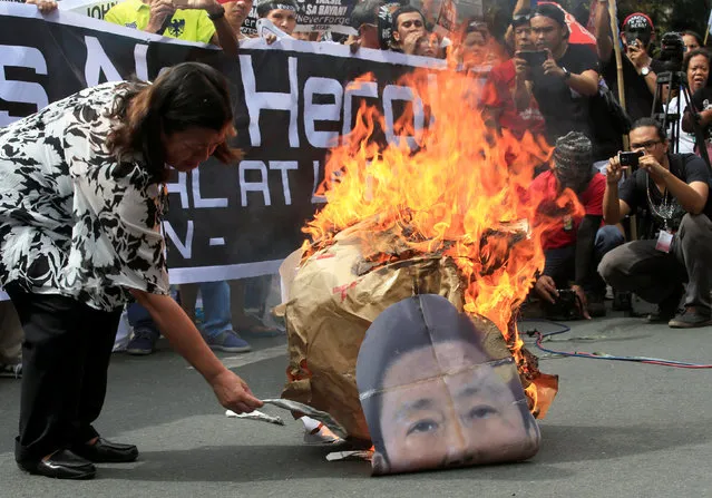 A protester burns an image of former Philippine dictator Ferdinand Marcos along a main street at Taft avenue, metro Manila, Philippines November 18, 2016. (Photo by Romeo Ranoco/Reuters)