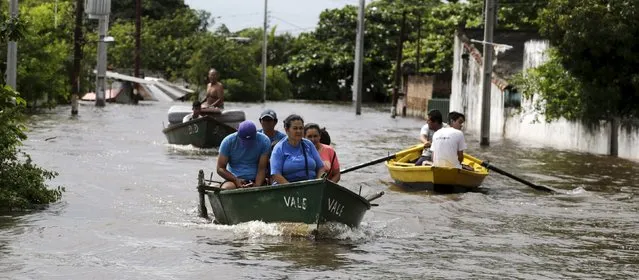 People travel on a boat near flood-affected houses in Asuncion, December 27, 2015. (Photo by Jorge Adorno/Reuters)