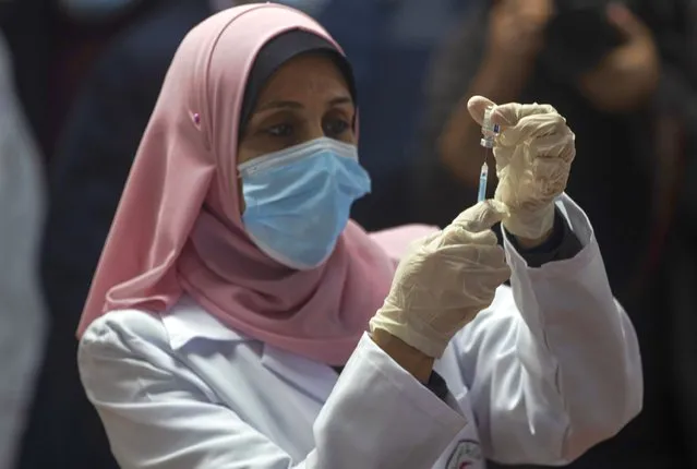 A Palestinian medic prepares a shot of the Russian-made Sputnik V coronavirus vaccine, in Gaza City, Monday, February 22, 2021. (Photo by Khalil Hamra/AP Photo)