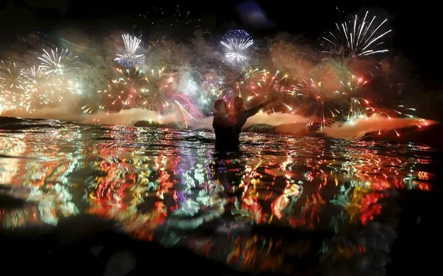 People watch as fireworks explode over Copacabana beach during New Year celebrations in Rio de Janeiro, Brazil, January 1, 2016. (Photo by Ricardo Moraes/Reuters)