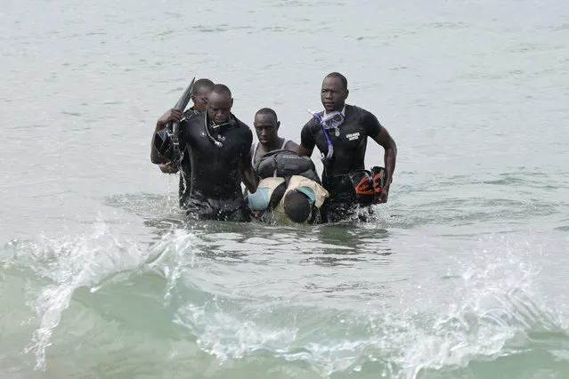 Senegalese rescue personnel remove a body of a victim from the ocean in Ouakam, in Dakar on July 24, 2023 after a boat capsized off the coast of Dakar. At least 14 people died after their wooden boat capsized off the Senegalese capital Dakar, the deputy mayor told AFP on July 24, 2023. (Photo by Seyllou/AFP Photo)