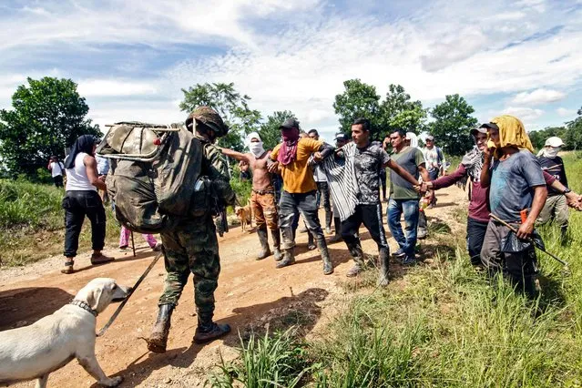 Coca growers block soldiers with the order of destroying plantations of the cocaine-yielding plant, in Caño Indio, Catatumbo, municipality of Tibú, Colombia, on May 11, 2022. A group of soldiers who were carrying out work an operation to eradicate illicit crops in the village of Los Cuervos, in the municipality of Tibú, in Norte de Santander Department, were surrounded by approximately 300 civilians who prevented them from completing their task. (Photo by Schneyder Mendoza/AFP Photo))