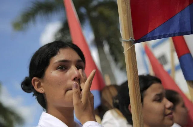 A woman wipes a tear as she watches as the caravan carrying Cuba's late President Fidel Castro's ashes passes through Las Tunas, Cuba, December 2, 2016. (Photo by Carlos Barria/Reuters)