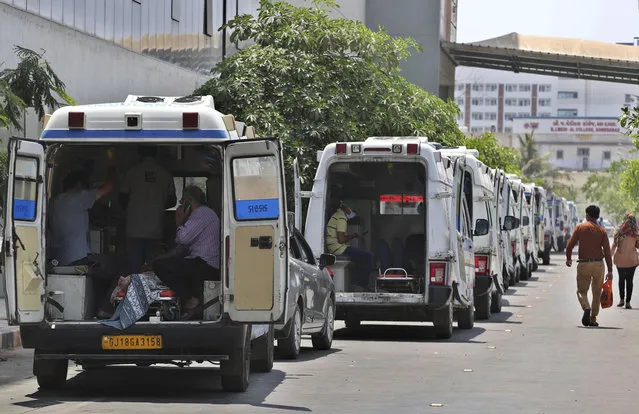 Ambulances carrying COVID-19 patients line up waiting for their turn to be attended to at a dedicated COVID-19 government hospital in Ahmedabad, India, Thursday, April 22, 2021. (Photo by Ajit Solanki/AP Photo)