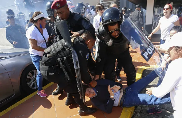 An anti-government protester is dragged away and arrested by police as security forces disrupt an opposition march coined “United for Freedom” in Managua, Nicaragua, Sunday, October 14, 2018. Anti-government protests calling for President Daniel Ortega's resignation are ongoing since April, triggered by a since-rescinded government plan to cut social security pensions. Ortega said opponents will have to wait until his term ends in 2021. (Photo by Alfredo Zuniga/AP Photo)