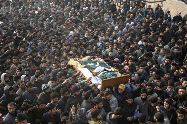 Kashmiri Muslim villagers carry the body of Basit Ahmad Dar, a suspected rebel of Hizbul Mujahideen, during his funeral procession in Marhama, 49 kilometers (31 miles) south of Srinagar, Indian controlled Kashmir, Wednesday, December 14, 2016. Dar and another suspected rebel were killed in two separate gun-battles with Indian security forces on Wednesday. (Photo by Mukhtar Khan/AP Photo)
