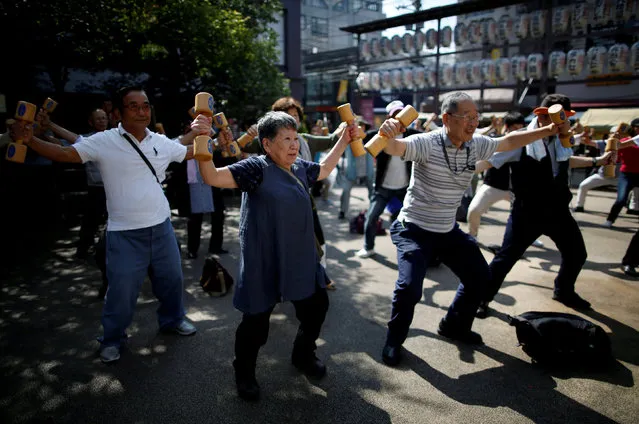 Participants including elderly and middle-aged people exercise with wooden dumbbells during a health promotion event to mark Japan's “Respect for the Aged Day” at a temple in Tokyo's Sugamo district, an area popular among the Japanese elderly, September 17, 2018. (Photo by Issei Kato/Reuters)