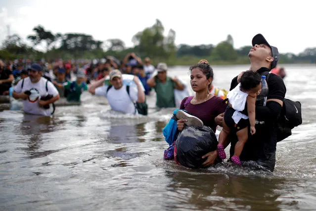 Daniel holds 1-year-old Daniela, both from El Salvador, as a caravan of migrants from Central America en route to the United States crossed through the Suchiate River into Mexico from Guatemala in Ciudad Hidalgo, Mexico on November 2, 2018. (Photo by Ueslei Marcelino/Reuters)