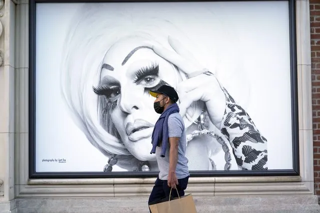 A shopper walks past a mural amid the COVID-19 pandemic on The Promenade Wednesday, June 9, 2021, in Santa Monica, Calif. (Photo by Marcio Jose Sanchez/AP Photo)