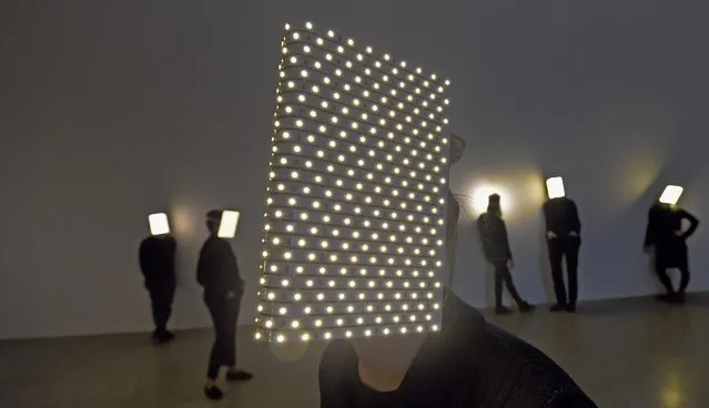 Extras wearing dark clothing and lit visors, so-called “Players” (2011), walk across an exhibition room as part of the installation “Orphan Patterns” by French artist Pierre Huyghe at the Sprengel Museum in Hanover, Germany, 28 January 2016. Huyghe will be awarded the Kurt Schwitters Prize 2015, sponsored by Lower Saxony's Sparkassen Foundation. (Photo by Holger Hollemann/EPA)
