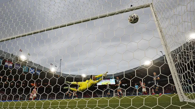 Croatia's Luka Modric scores his side's second goal against Scotland's goalkeeper David Marshall during the Euro 2020 soccer championship group D match between Croatia and Scotland at the Hampden Park Stadium in Glasgow, Tuesday, June 22, 2021. (Photo by Petr David Josek/AP Photo/Pool)