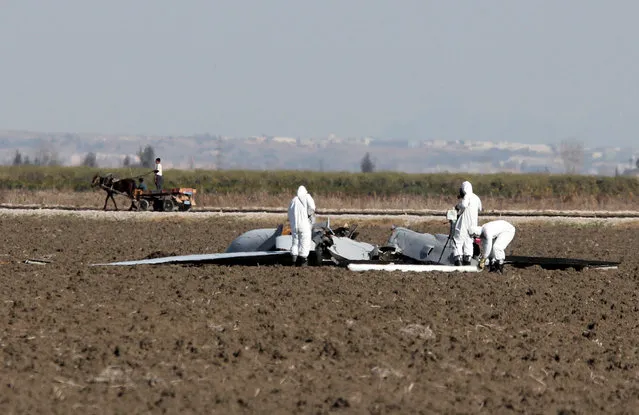 U.S. military forensic experts investigate the remains of a Predator drone near Incirlik Air Base, Adana, Turkey, Wednesday, February 3, 2016. U.S. military officials have confirmed Turkish media reports that an American Predator drone has crashed on a field near Incirlik Air Base in southern Turkey. U.S. Air Forces Europe spokeswoman Capt. Lauren Ott said the remotely piloted aircraft crashed early on Wednesday. No one was hurt in the incident. (Photo by Depo Photos via AP Photo)