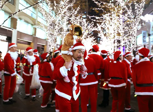 Some 300 office workers in the Marunouchi area in Santa Claus costumes marching for the Marunouchi Christmas Parade on the illuminated Nakadori street in Tokyo's Marunouchi business district on December 21, 2018. (Photo by Aflo/Rex Features/Shutterstock)