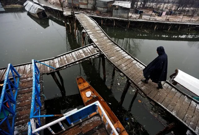 A man walks on a footbridge at Dal Lake during a snowfall on a cold winter morning in Srinagar January 4, 2017. (Photo by Danish Ismail/Reuters)