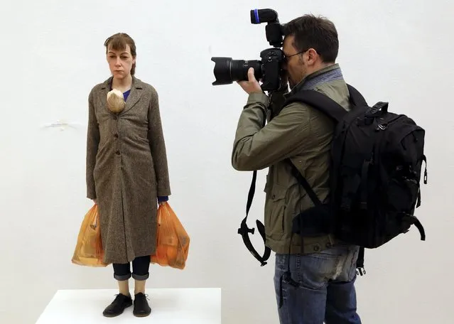 A photographer takes a picture of “Woman with shopping” by Ron Mueck during the unveiling of the Arts & Food exhibition at the Triennale as part of the upcoming Expo 2015 in downtown Milan April 8, 2015. The theme of this year's Expo is “Feeding the Planet, Energy for Life”, and it will run from May 1 to October 31, 2015. (Photo by Stefano Rellandini/Reuters)