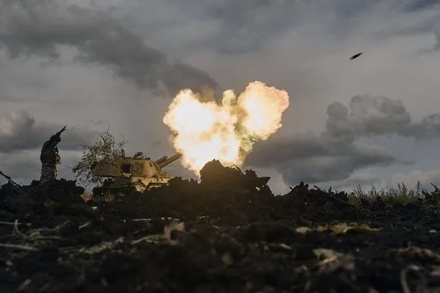 A Ukrainian serviceman reacts as a self-propelled artillery vehicle fires near Bakhmut, Donetsk region, Ukraine, Saturday, October 22, 2022. (Photo by LIBKOS/AP Photo)