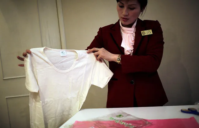 In this January 9, 2017, photo, a saleswoman holds up a locally produced t-shirt made out of Hemp in Pyongyang, North Korea, which has been getting some pretty high praise lately from the stoner world. The claim that marijuana is legal in North Korea and that if any laws do exist they aren't enforced is emphatically not true according to the North Korean penal code, which lists it as a controlled substance in the same category as cocaine and heroin, and the people who would likely be called in to try to get any foreigner violating them out of jail. Hemp is, in fact, grown in North Korea with official sanction. It's used to make cooking oil and military uniforms and belts. (Photo by Wong Maye-E/AP Photo)