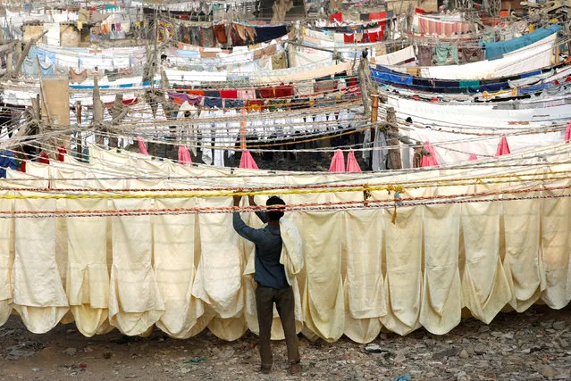 A laundry man removes chair covers from a rope after a wash and dry at a Dhobi Ghat (washing place) in Karachi, Pakistan January 4, 2019. (Photo by Akhtar Soomro/Reuters)