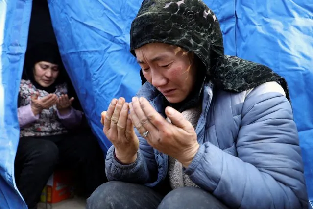 Women pray for Ma Jinyuan, an 8-year-old girl who passed away, at a temporary shelter at Yangwa village following the earthquake in Jishishan county, Gansu province, China on December 21, 2023. (Photo by Xiaoyu Yin/Reuters)