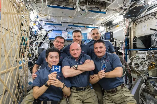 The Expedition 45 crew gathers inside the Destiny laboratory to celebrate the 15th anniversary of continuous human presence aboard the International Space Station. Front row: Japanese astronaut Kimiya Yui (left) and NASA astronauts Scott Kelly (middle) and Kjell Lindgren. Back row: Russian cosmonauts Sergey Volkov (left), Oleg Kononenko (middle) and Mikhail Kornienko (right). Yui is seen holding the mission patch for Expedition 1 which arrived at the station on November 2, 2000. (Photo by NASA)
