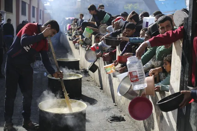 Palestinians line up for a free meal in Rafah, Gaza Strip, Wednesday, December 20, 2023. (Photo by Hatem Ali/AP Photo)