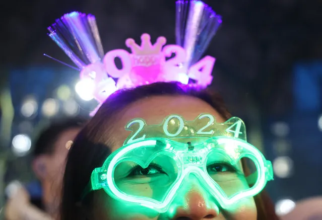 A reveller wears 2024 glasses during the New Year Eve firework celebrations on the River Thames in London, Britain on December 31, 2023. (Photo by Neil Hall/EPA/EFE)