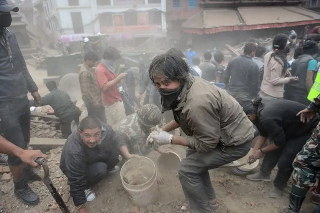 People clear rubble in Kathmandu's Durbar Square, a UNESCO World Heritage Site that was severely damaged by an earthquake on April 25, 2015. (Photo by Prakash Mathema/AFP Photo)