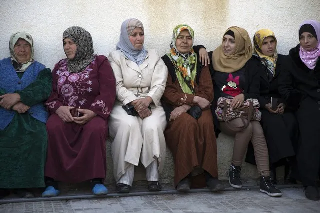 Turkmen women wait for the distribution of humanitarian aid by Russian military and the Syrian Arab Red Crescent in Al-Issawiyah, about 15 kilometers of Turkish border, Syria, Friday, March 4, 2016. (Photo by Pavel Golovkin/AP Photo)
