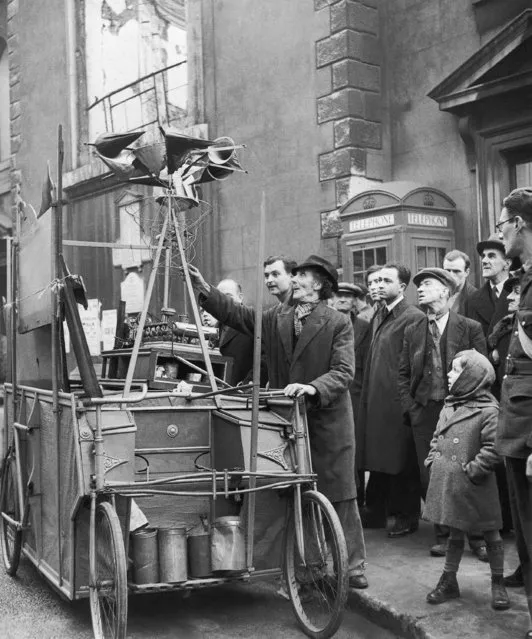 John Dyson, 63-year-old inventor, gets his perfected bomber destroyer, which is mounted on a bicycle cart, ready for a tour of London streets to impress the public, December 15, 1941, since British Government authorities remain indifferent to its potentialities. Mr. Dyson blames the old-school-tie crowd in the Government for the disinterest shown in his working model. Mr. Dyson presses buttons, turns innumerable gadgets, and the steam whistles and something starts turning with squeaks of protests, and gradually the whole business starts whirling and bobbing up and down, and then, according to him, you are witnessing a model of the machine that will save any country from bombers. After lecturing the curious, he asks for coins so that he may continue his research and buy a new alarm clock, as a new clock would help the cause. (Photo by AP Photo)