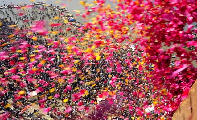 State government officials throw flowers from a helicopter as Hindu devotees throng Sangam, the confluence of the rivers Ganges and the Yamuna on “Mauni Amavasya” in Prayagraj, India, Friday, February 9, 2024. “Mauni Amavasya” is a new moon day, considered auspicious for bathing here during the ongoing annual month long Hindu religious fair “Magh Mela”. (Photo by Rajesh Kumar Singh/AP Photo)