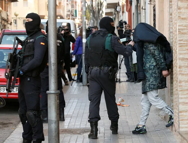 Spanish civil guards escort a detained suspect, accused of recruiting and training potential combatants for the Islamic State, in Badalona, northeastern Spain, February 7, 2017. (Photo by Albert Gea/Reuters)