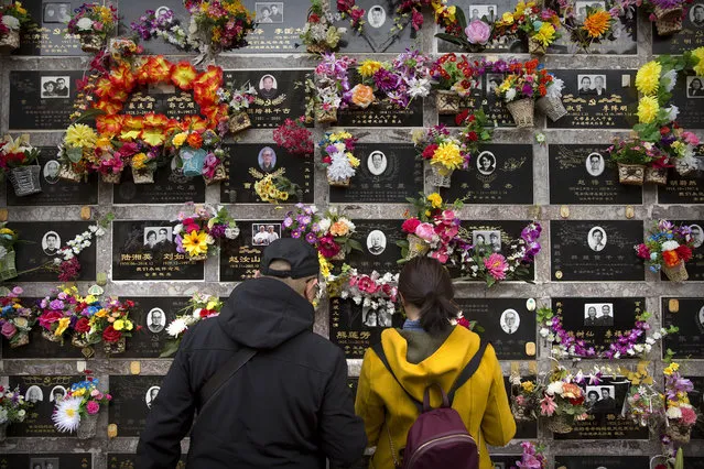 Visitors look at a columbarium at the Babaoshan Revolutionary Cemetery during the Qingming festival in Beijing, Friday, April 5, 2019. Qingming festival, also known as the Grave Sweeping Day, is a day when Chinese around the world remember their dearly departed and take time off to clean up the tombs and place flowers and offerings. (Photo by Mark Schiefelbein/AP Photo)