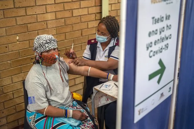 An Orange Farm, South Africa, resident receives her jab against COVID-19 Friday December 3, 2021 at the Orange Farm multipurpose center. South Africa has accelerated its vaccination campaign a week after the discovery of the omicron variant of the coronavirus. (Photo by Jerome Delay/AP Photo)
