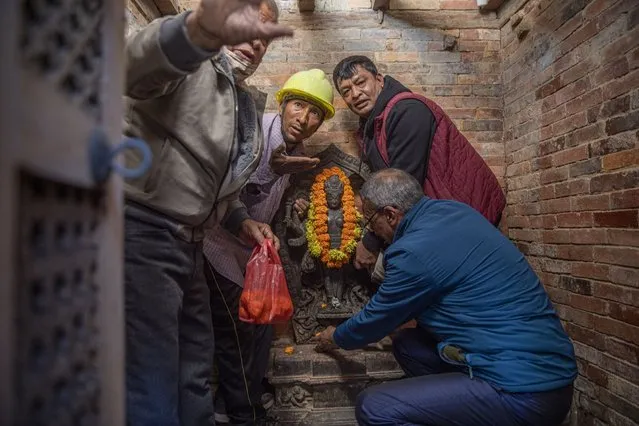 Nepalese devotees reinstall the stone statue of Laxmi-Narayan at a temple in Patan city, Nepal, 04 December 2021. The rare stone statue of Laxmi-Narayan believed to be 800 years old was stolen in 1984 and later spotted at the Dallas Museum of Art. The US Federal Bureau of Investigation (FBI) handed over the statue to the Nepal embassy in Washington, USA, on 06 March 2021. (Photo by Narendra Shrestha/EPA/EFE)