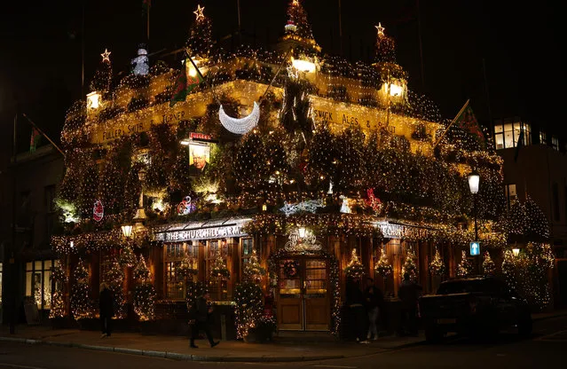 The Churchill Arms on Kensington Church Street is adorned in Christmas lights on December 16, 2021 in London, England. The Churchill Arms is often cited as London's most famous pub and was once the haunt of Winston Churchill's grandparents. Each Christmas the exterior is bedecked with 80 actual Christmas trees and 22000 of light. (Photo by Dan Kitwood/Getty Images)