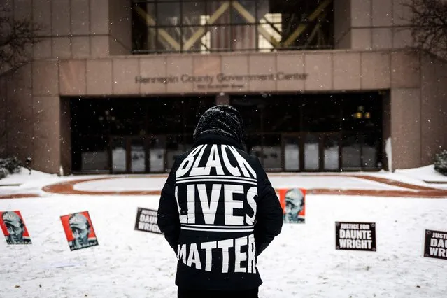 A person demonstrates in support of Daunte Wright outside the Hennepin County Government Center in Minneapolis, Minnesota, on December 21, 2021, during jury deliberations in the trial of former police officer Kim Potter. Potter, 49, is charged with first degree manslaughter over the fatal shooting of Wright, 20, in Brooklyn Center, a suburb of Minneapolis, Minnesota, in April 11, 2021. She claims the shooting was an accident, saying she mistakenly grabbed her gun instead of her Taser. (Photo by Kerem Yucel/AFP Photo)