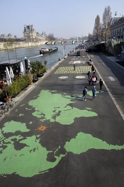 Tourists and Parisians enjoy the recently open promenade on the left bank of the Seine river in Paris, Friday March 14, 2014. Paris Mayor election candidate Anne Hidalgo wants to expand her predecessor’s walkway along the banks of the Seine and the newly fashionable areas around Paris’ canal district. (Photo by AP Photo/Remy de la Mauviniere)