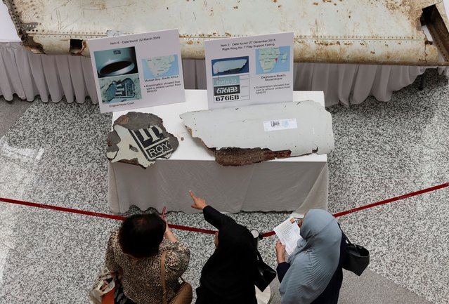 Visitors look at the wreckage of an aircraft believed to be from the missing Malaysia Airlines flight MH370 during a remembrance event marking the 10th anniversary of its disappearance, in Subang Jaya, Malaysia on March 3, 2024. (Photo by Hasnoor Hussain/Reuters)