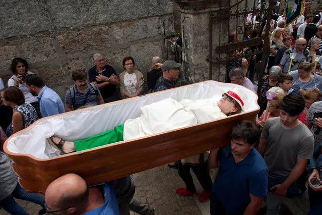 A woman lies inside coffins as they are carried during the traditional pilgrimage to Saint Marta de Ribarteme, Galicia, Spain, 29 July 2019. The festival is held to show the gratitude of people who once asked for good health while being ill. People who recovered are carried in procession inside coffins. Children who regained their health are not allowed to take part in the pilgrimage, but small white empty coffins are taken instead to represent them. (Photo by Salvador Sas/EPA/EFE)