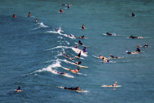 Surfers ride a wave on a hot Autumn day at Freshwater Beach in Sydney on March 12, 2024. (Photo by David Gray/AFP Photo)