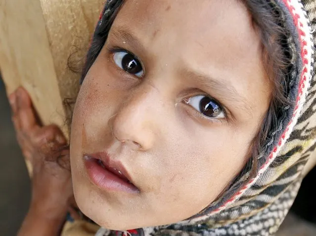 The photographer is reflected in the eyes of a Yemeni girl posing for a photo near a makeshift shelter at a camp for Internally Displaced Persons (IDPs) after they were forced to flee their homes due to the ongoing fighting in the country, the northern province of Amran, Yemen, 01 May 2016. According to reports, a yearlong conflict between the Saudi-backed Yemeni forces and the Houthi rebels has left more than 2.4 million people forcibly displaced, pushing this impoverished Arab country to the brink of humanitarian crisis. (Photo by Yahya Arhab/EPA)