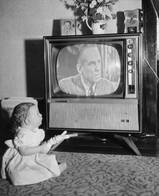 Eight month old Andrea Whalen holds trick rabbit that causes the television set to change channels when bunny is pressed and squeaks on February 6, 1961. Set has a remote control device which is evidently activated by squeak from rabbit. (Photo by AP Photo)