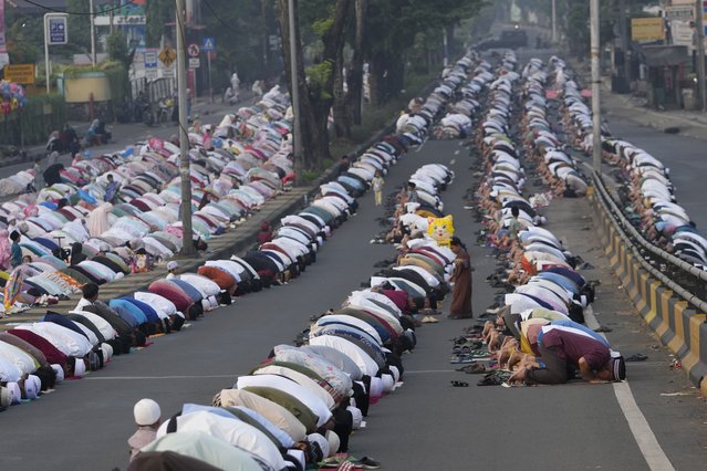 Muslims perform Eid al-Adha prayer on a street in Jakarta, Indonesia, Monday, June 17, 2024. Muslims around the world celebrate Eid al-Adha by sacrificing animals to commemorate the prophet Ibrahim's faith in being willing to sacrifice his son. (Photo by Achmad Ibrahim/AP Photo)