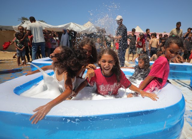 Inflatable pools were set up by volunteer youth to cool children living in tents in Khan Yunis city of Gaza under Israeli attacks, on July 18, 2024. (Photo by Hassan Jedi/Anadolu via Getty Images)